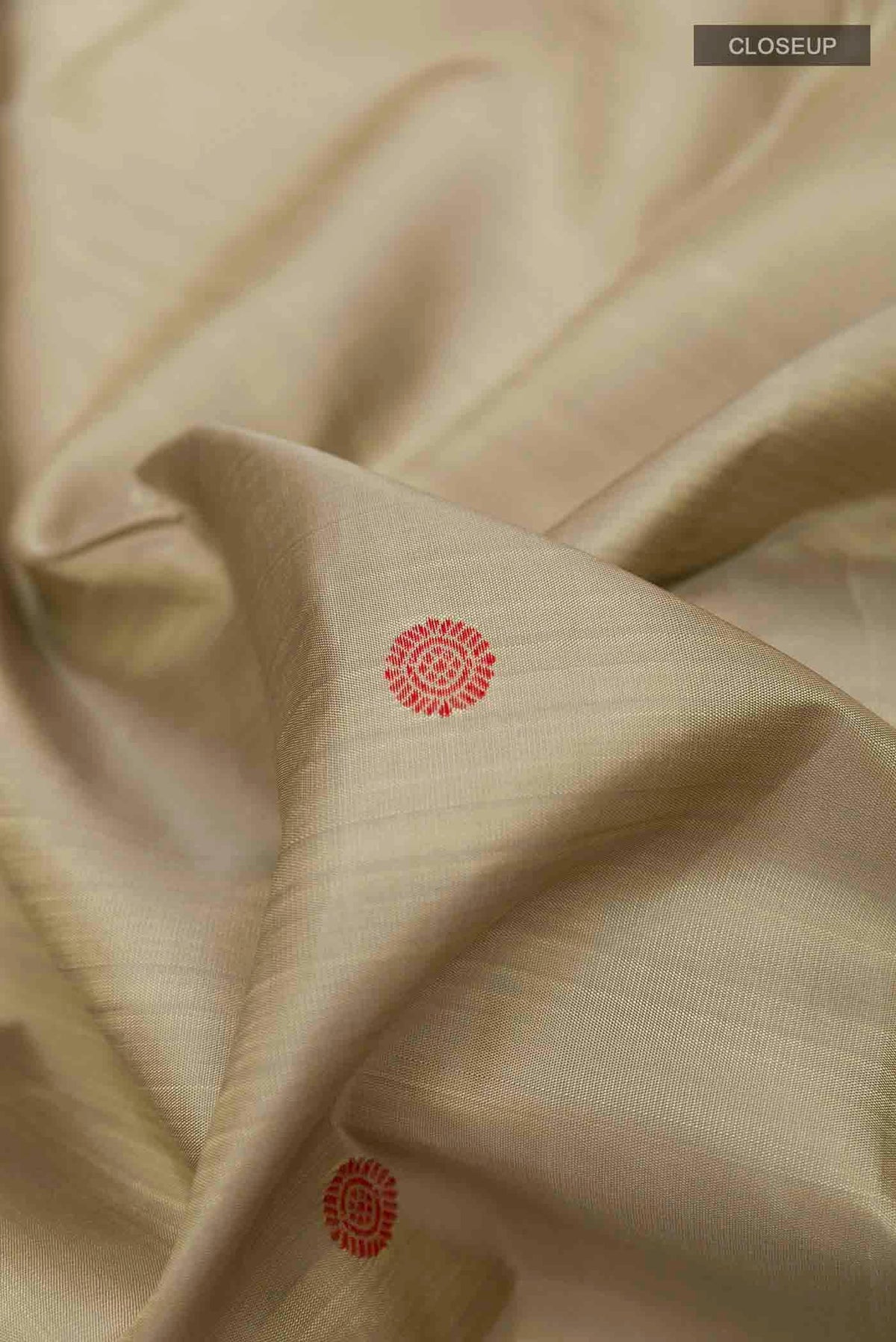 Close up of Beige Kanchipuram Silk Saree with Thread Butta on the body and Thread Border displaying folds
