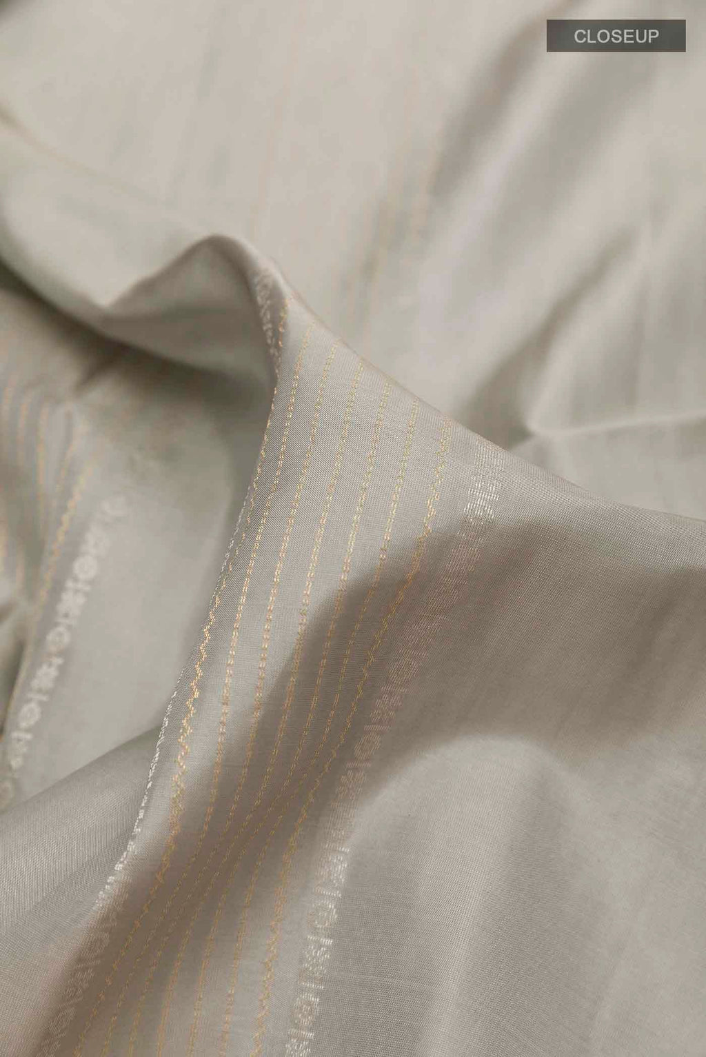 Close up of Grey Soft Silk Saree with Stripes on the body and Zari Border displaying folds