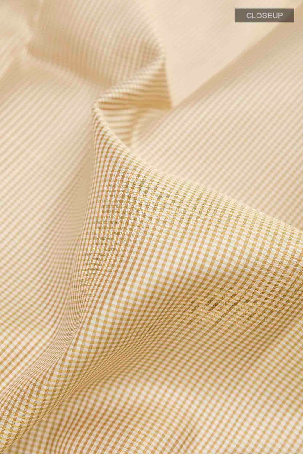 Close up of Off White Kanchipuram Silk Saree with Checked design on the body and Zari Border displaying folds