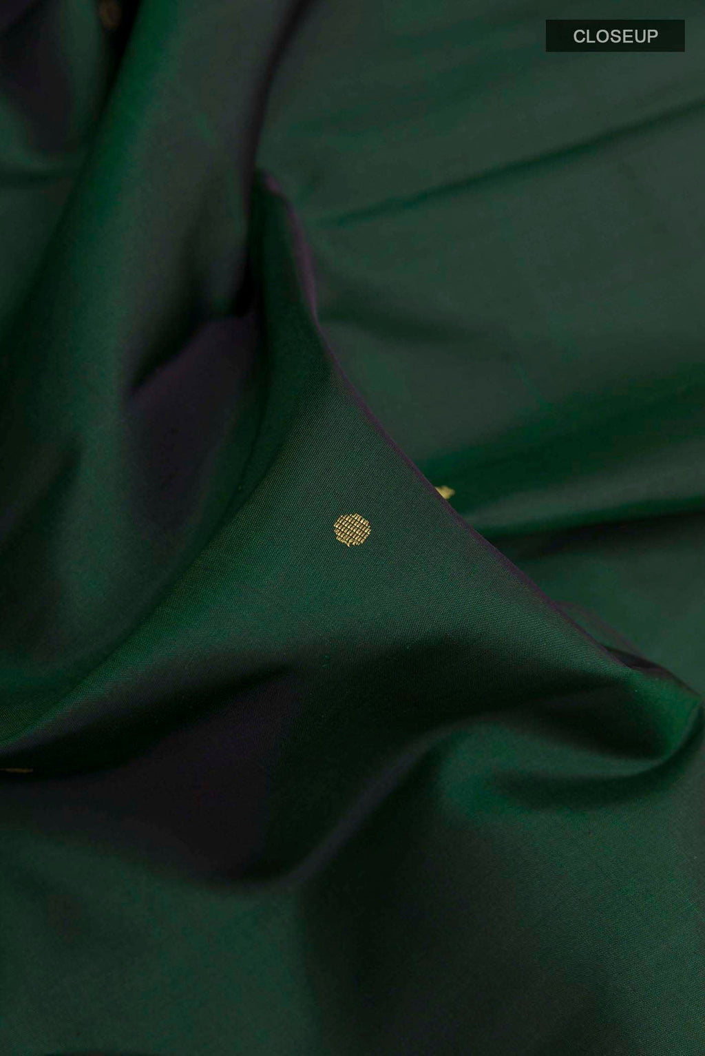 Close up of Bottle Green Kanchipuram Silk Saree with Zari Butta on the body and Zari Border displaying folds
