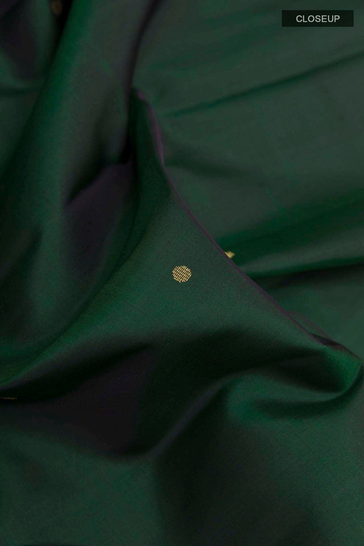 Close up of Bottle Green Kanchipuram Silk Saree with Zari Butta on the body and Zari Border displaying folds