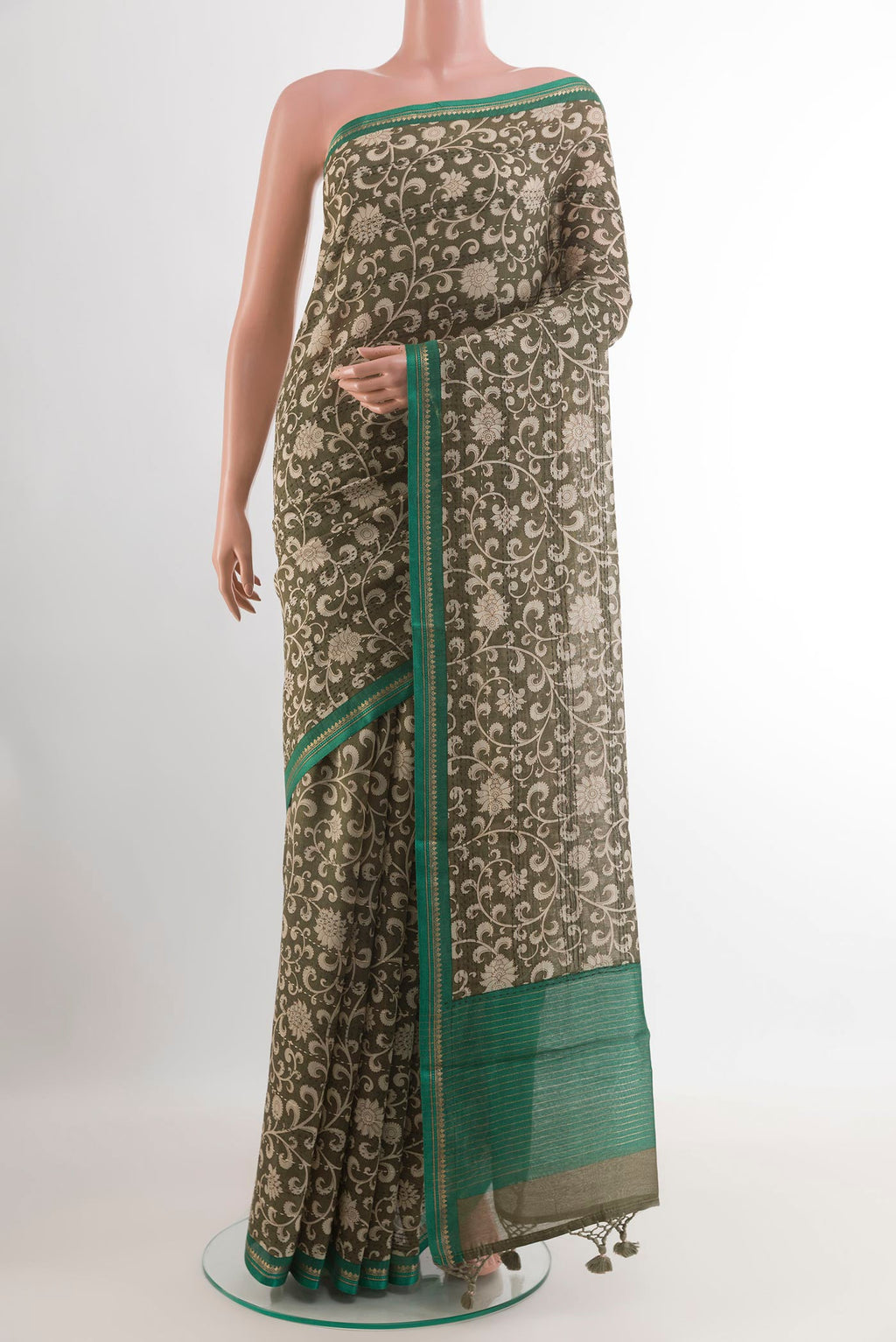 Mehandi Green Tussar Saree with Printed design on the body and Zari Border.  displayed on a mannequin