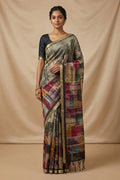 Model wearing a Grey Tussar Silk Saree with Printed design on the body and Zari Border.