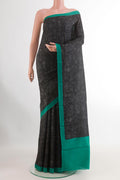 Black Printed Silk Saree with Printed design on the body and Printed Border.  displayed on a mannequin