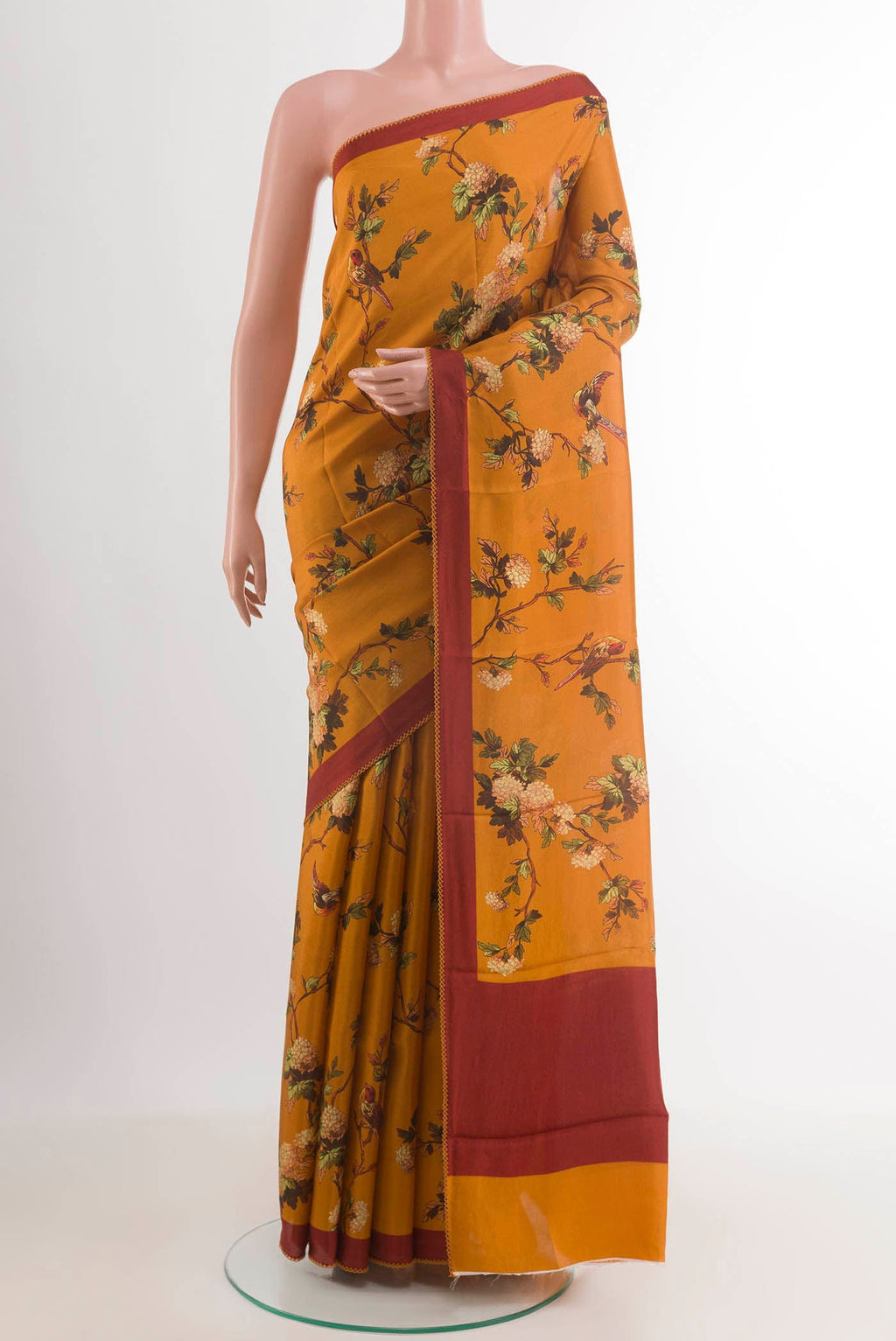 Mustard Printed Silk Saree with Printed design on the body and Plain Border.  displayed on a mannequin