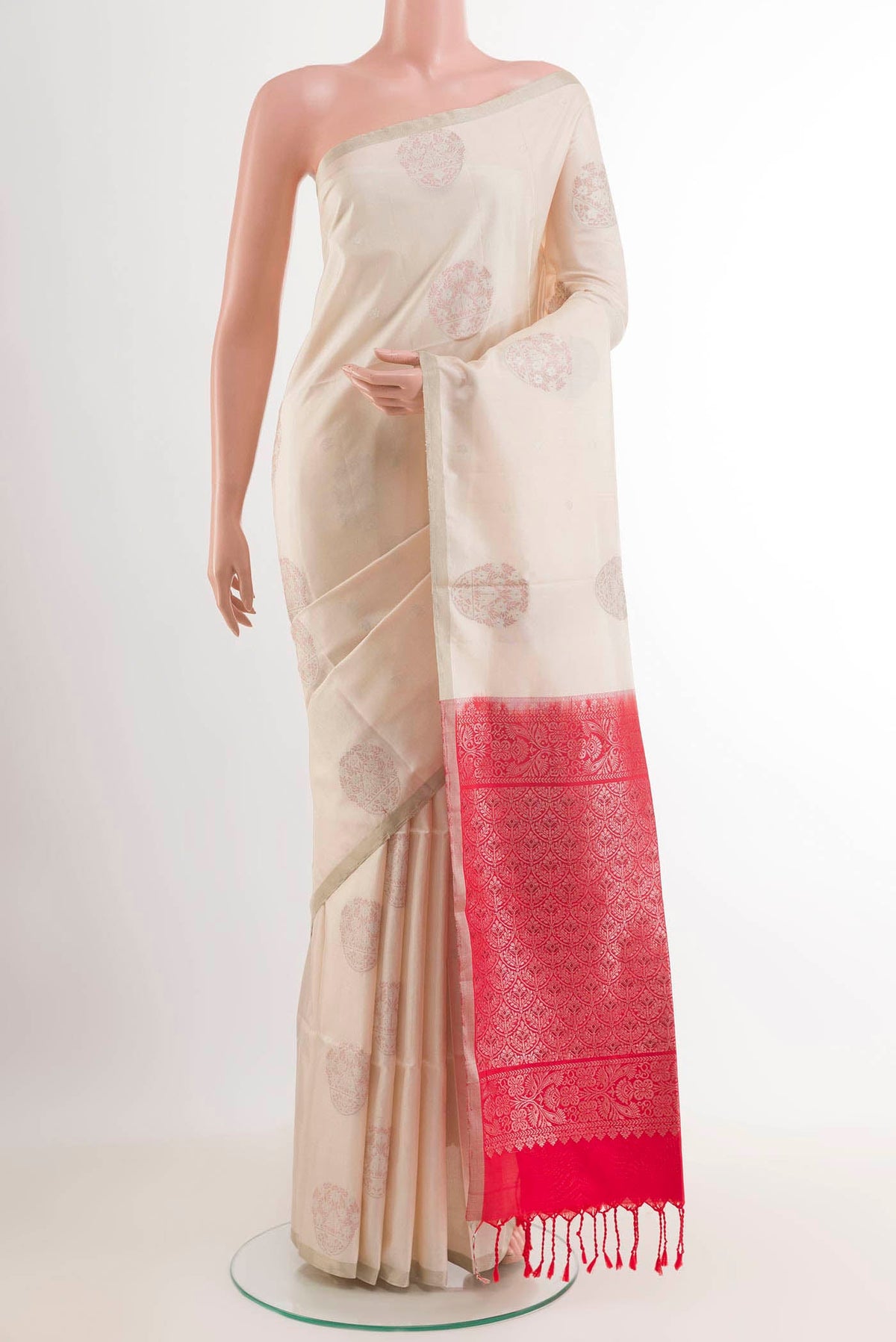 Off White Soft Silk Saree with Zari Butta on the body and Zari Border.  displayed on a mannequin