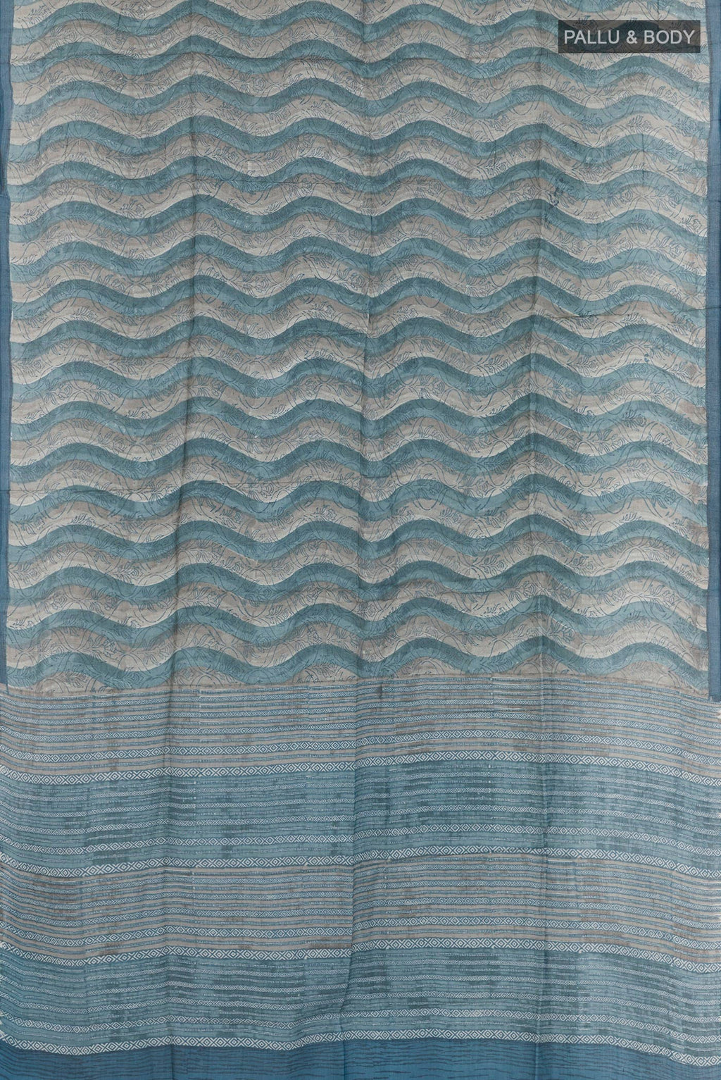 Flat view of Blue Tussar Saree with Printed design on the body and Zari Border. 