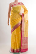 Yellow Linen Saree with Zari Butta on the body and Zari Border.  displayed on a mannequin