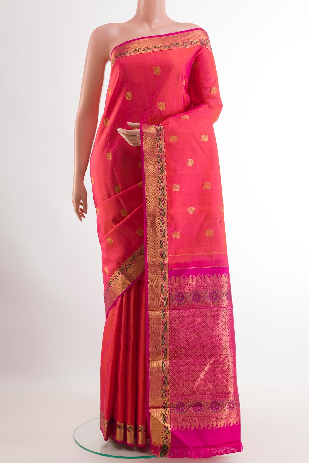 Orange with Pink Color Kanchipuram Silk Saree with Zari Butta on the body and Zari Border.  displayed on a mannequin