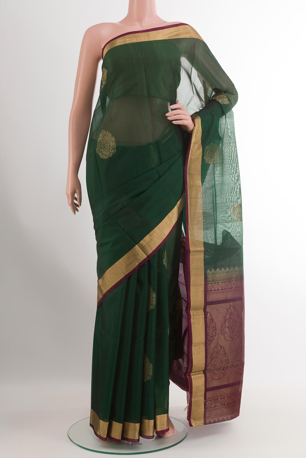 Bottle Green Silk Cotton Saree with Zari Butta on the body and Zari Border.  displayed on a mannequin