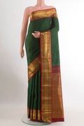Bottle Green Kanjivaram Silk Saree with Zari Butta on the body and Zari Border.  displayed on a mannequin
