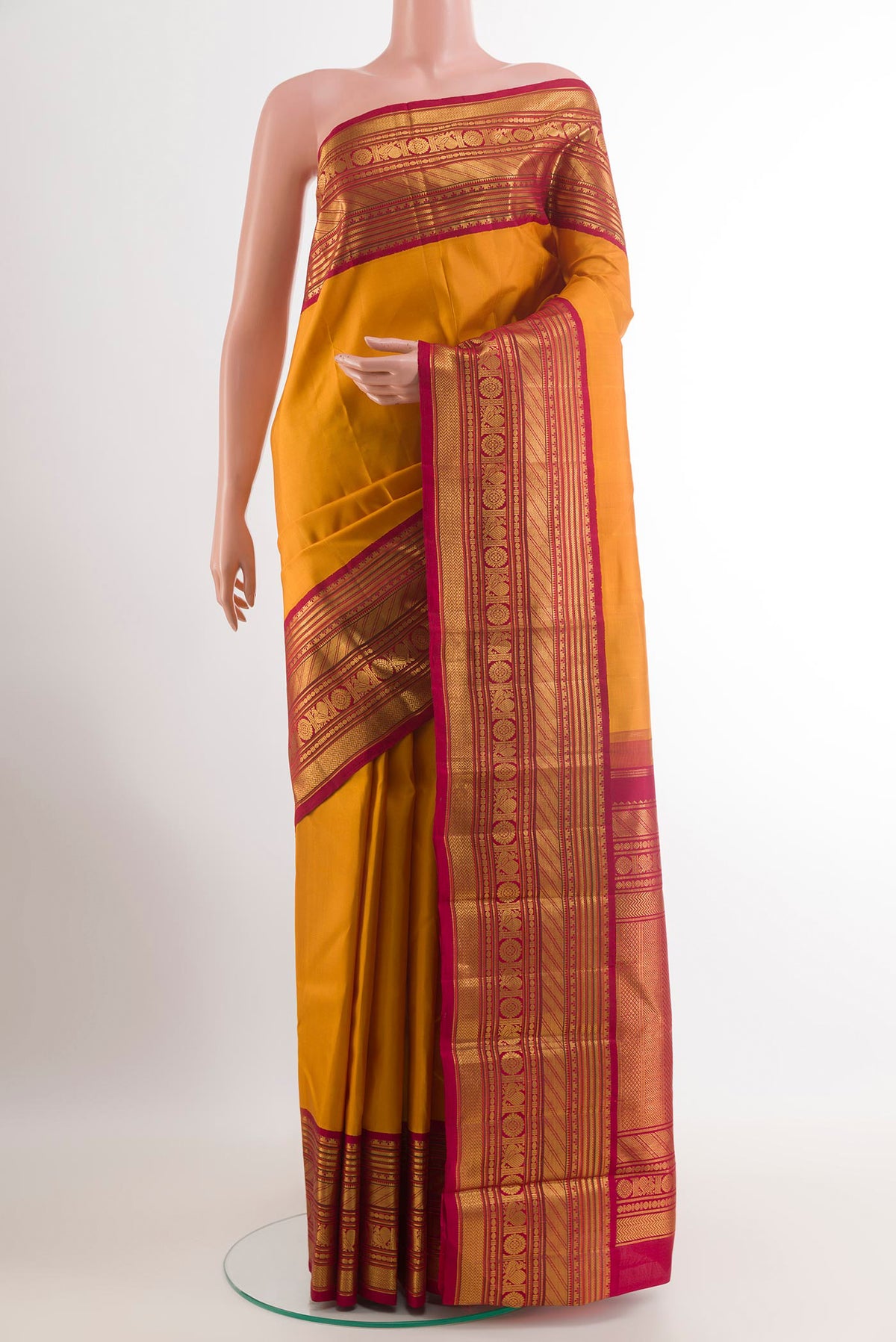 Mustard Kanjivaram Silk Saree with Plain Body and Zari Border.  displayed on a mannequin