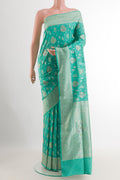 Turquoise Banarasi Silk Saree with Zari Butta on the body and Zari Border.  displayed on a mannequin