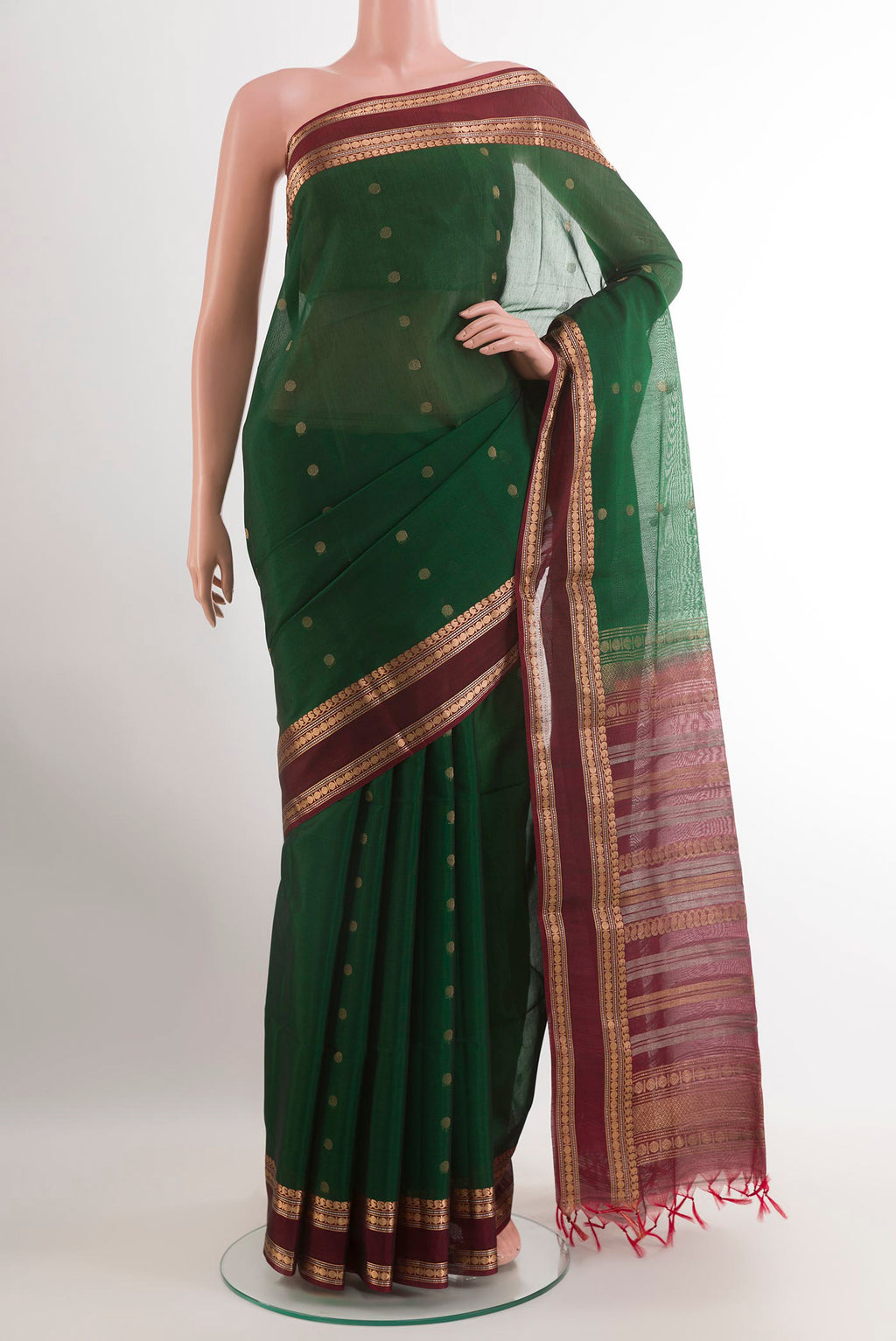 Bottle Green Silk Cotton Saree with Zari Butta on the body and Zari Border.  displayed on a mannequin