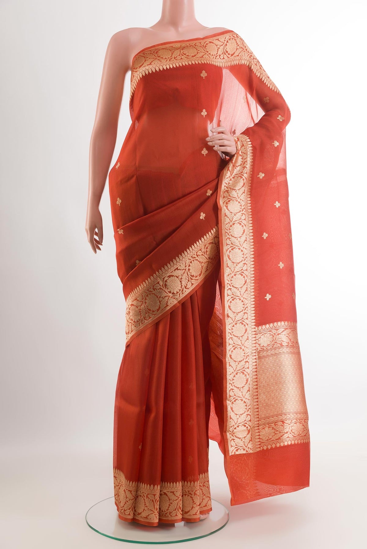 Orange Organza Silk Saree with Zari Butta on the body and Zari Border.  displayed on a mannequin