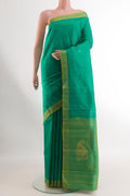 Green Kanchipuram Silk Saree with Zari Butta on the body and Zari Border.  displayed on a mannequin