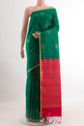 Green Raw Silk Saree with Zari Butta on the body and Zari Border.  displayed on a mannequin