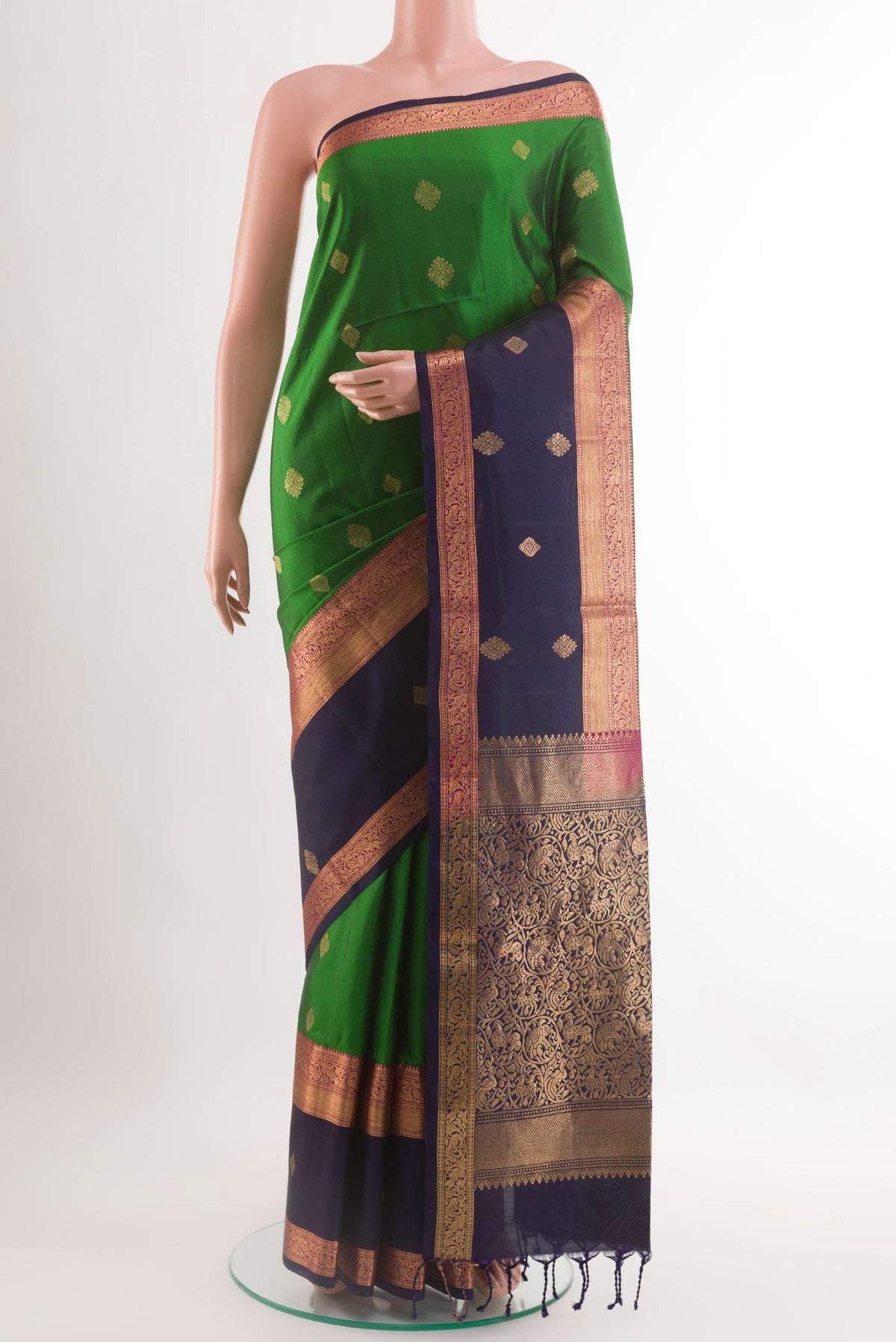 Green Soft Silk Saree with Zari Butta on the body and Zari Border.  displayed on a mannequin