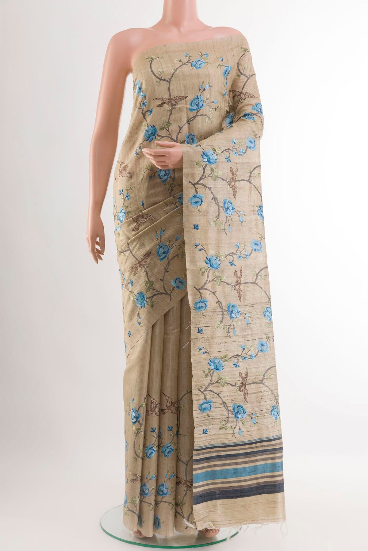 Beige Tussar Saree with Embroidery on the body and Embroidery Border.  displayed on a mannequin
