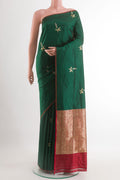 Green Banarasi Katan Silk Saree with Zari Butta on the body and Zari Border.  displayed on a mannequin