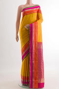 Mustard Kanchipuram Silk Saree with Zari Butta on the body and Zari Border.  displayed on a mannequin