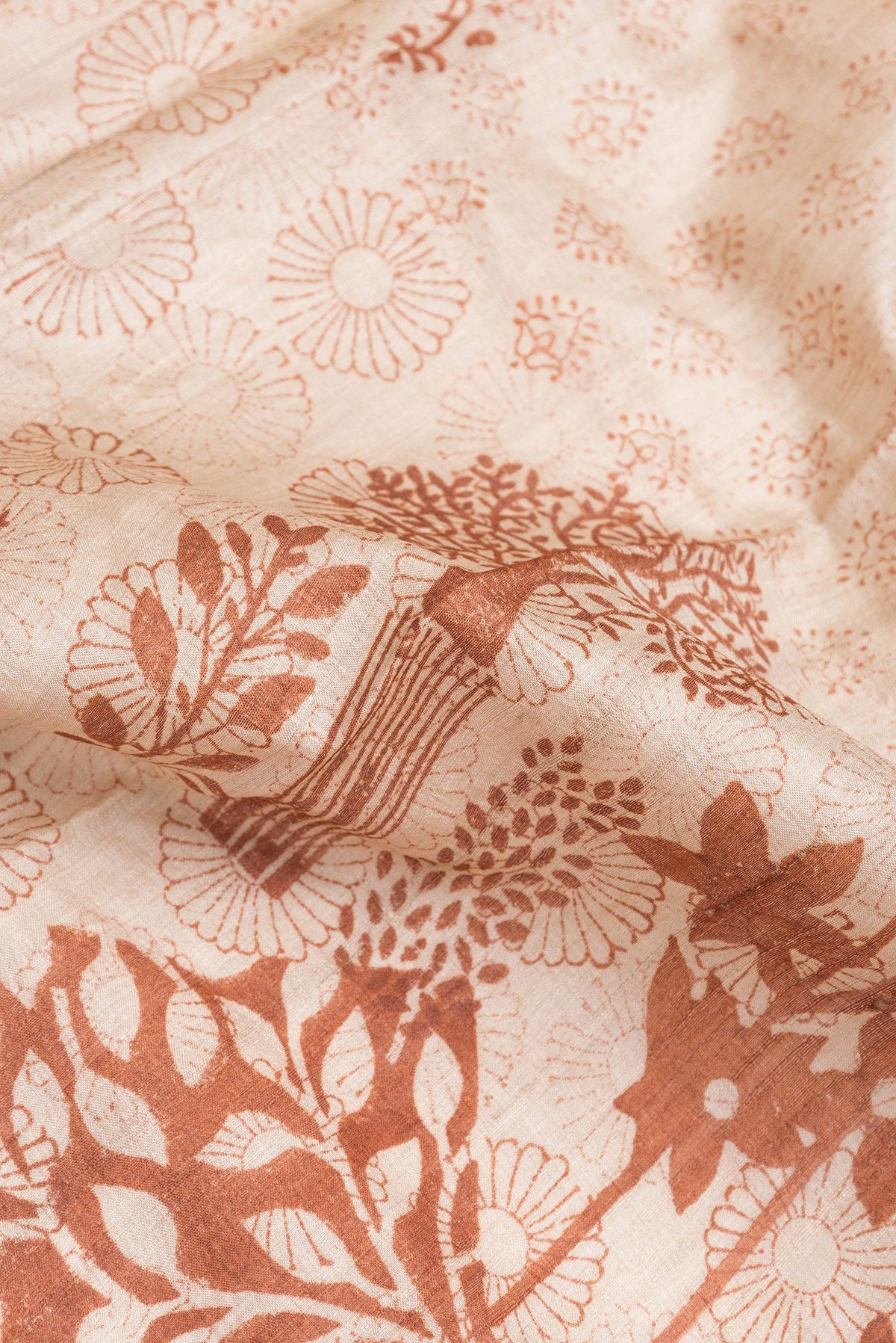 Close up of Beige Tussar Silk Saree with Printed design on the body and Printed Border.  displaying folds
