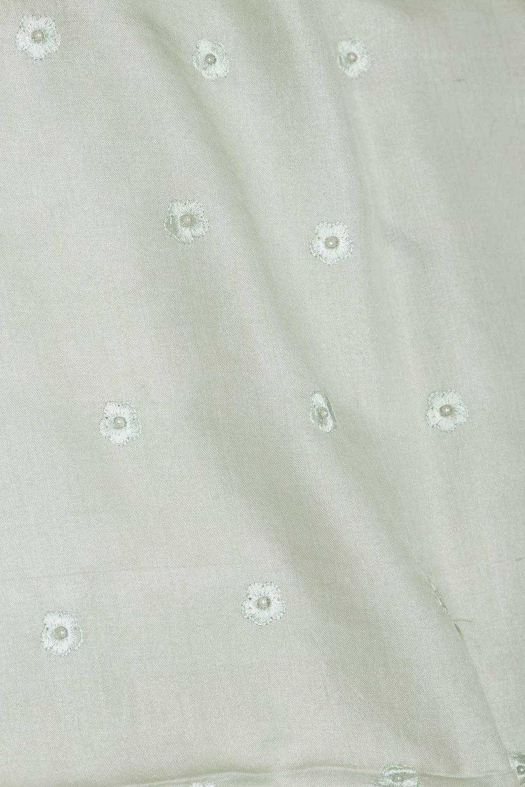 Close up of Pista Green Dual Tone Tussar Saree with Embroidery on the body and Embroidery Border displaying folds