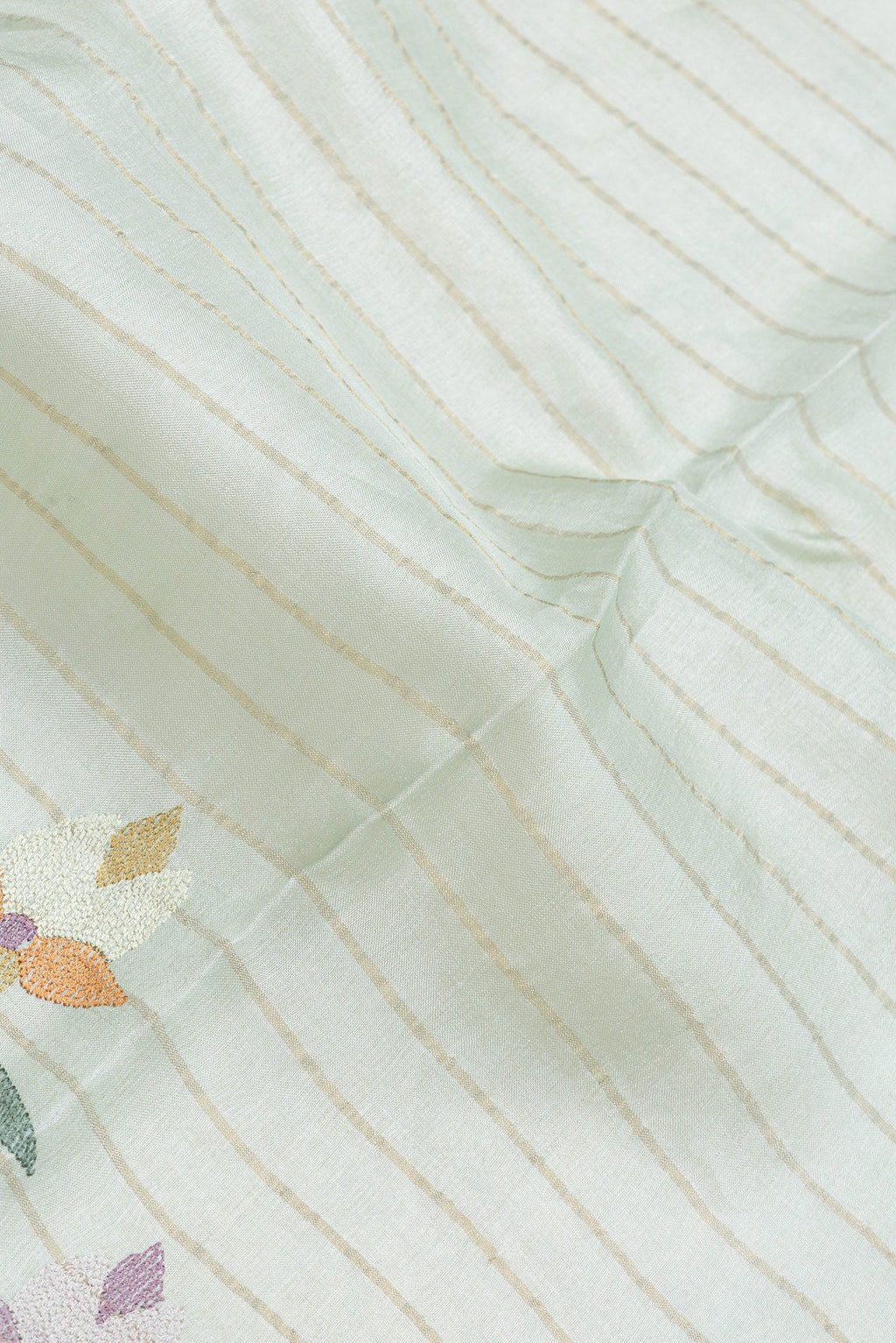 Close up of Sea Green Dual Tone Tussar Silk Saree with Stripes on the body and Embroidery Border.  displaying folds