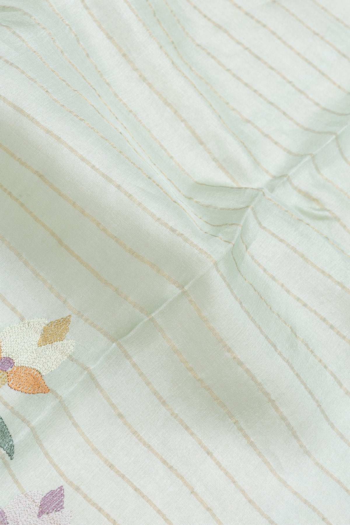 Close up of Sea Green Dual Tone Tussar Silk Saree with Stripes on the body and Embroidery Border.  displaying folds