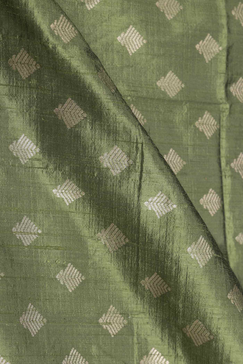 Close up of Green Dual Tone Raw Silk Saree with Zari Brocade on the body and Zari Border displaying folds