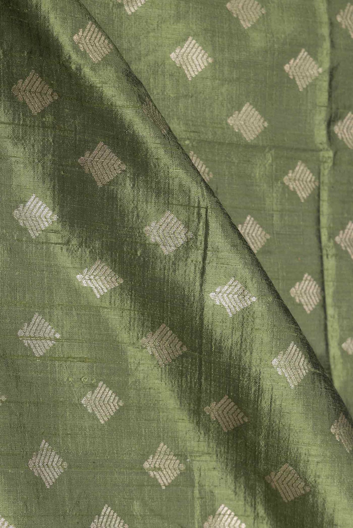 Close up of Green Dual Tone Raw Silk Saree with Zari Brocade on the body and Zari Border displaying folds