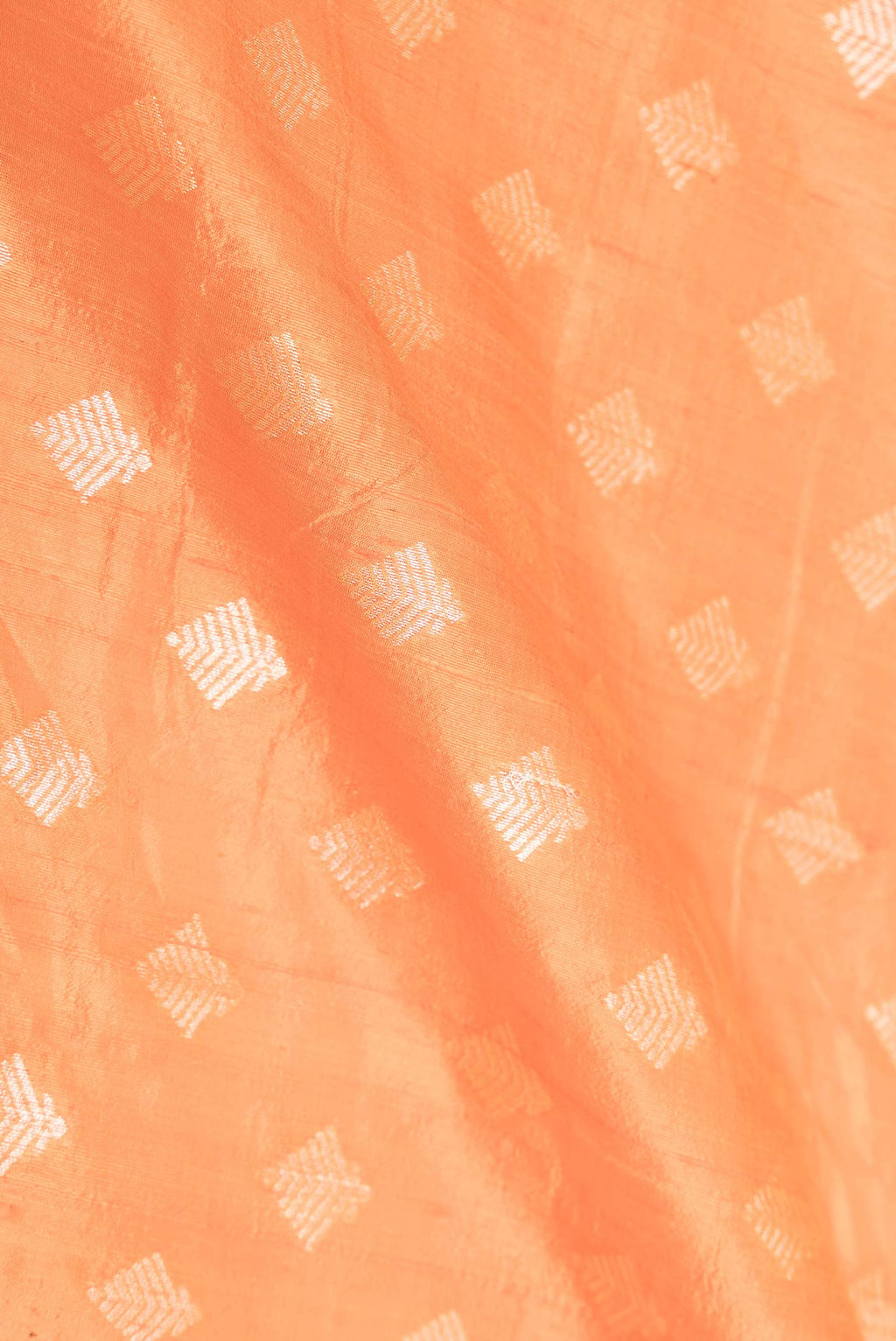 Close up of Orange Dual Tone Raw Silk Saree with Zari Brocade on the body and Zari Border displaying folds