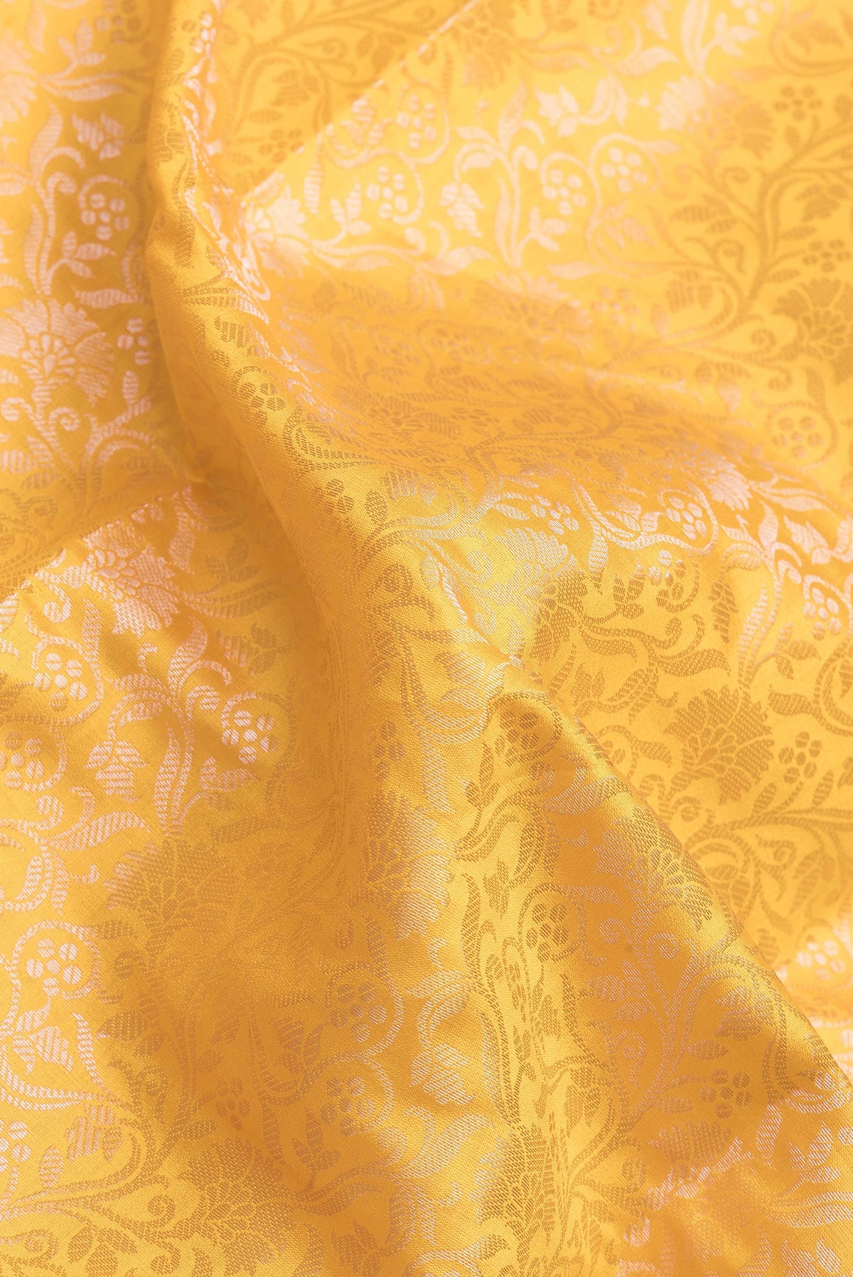 Close up of Yellow Dual Tone Banarasi Raw Silk Saree with Zari Brocade on the body and Zari Border.  displaying folds