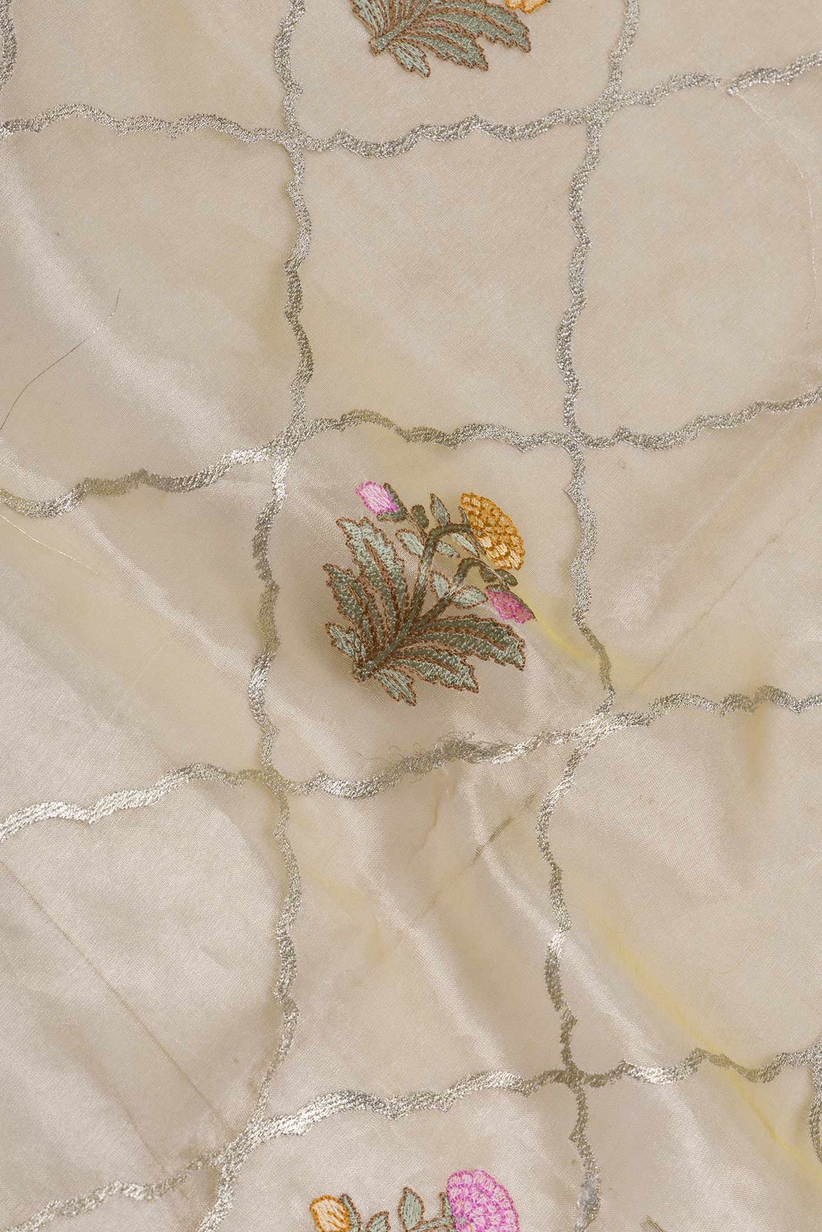Close up of Gold Dual Tone Organza Silk Saree with Zari And Thread Butta on the body and Zari Border displaying folds