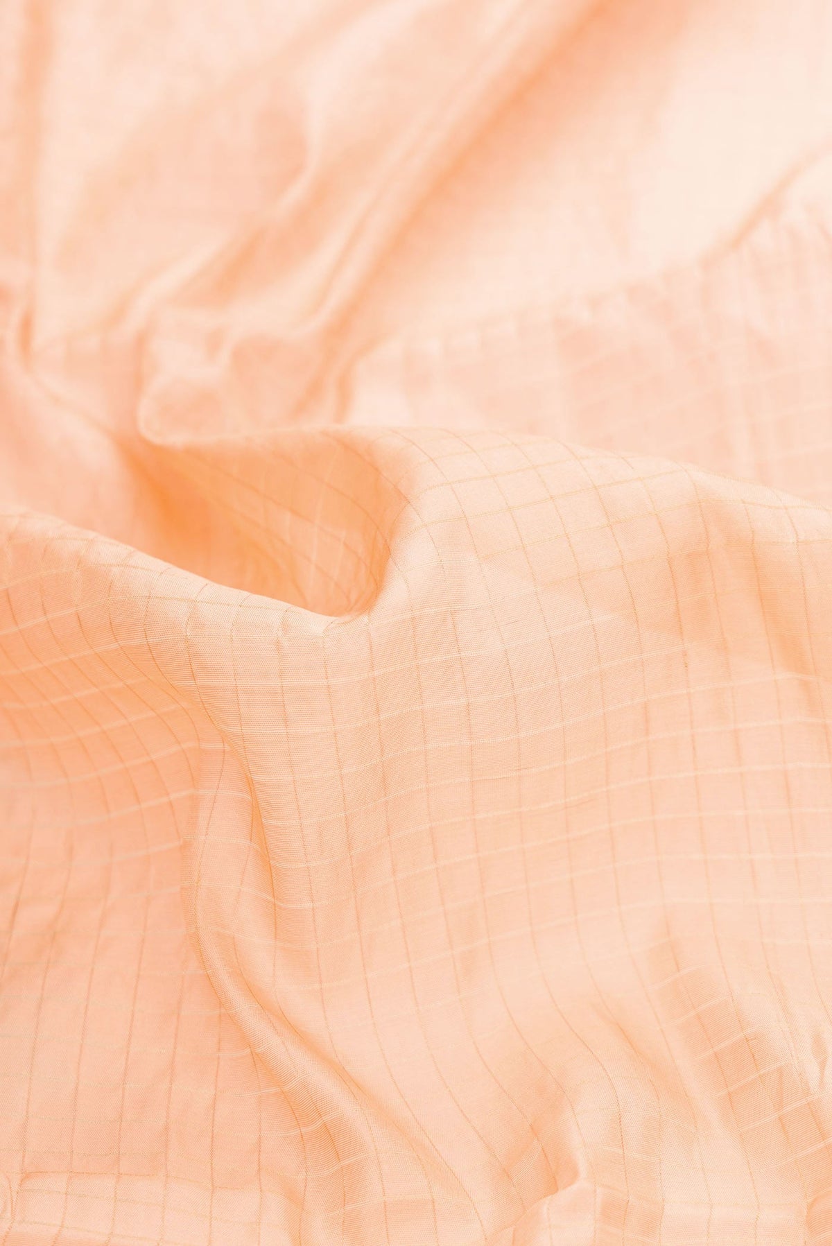 Close up of Orange Dual Tone Tussar Silk Saree with Stripes on the body and Zari Border displaying folds