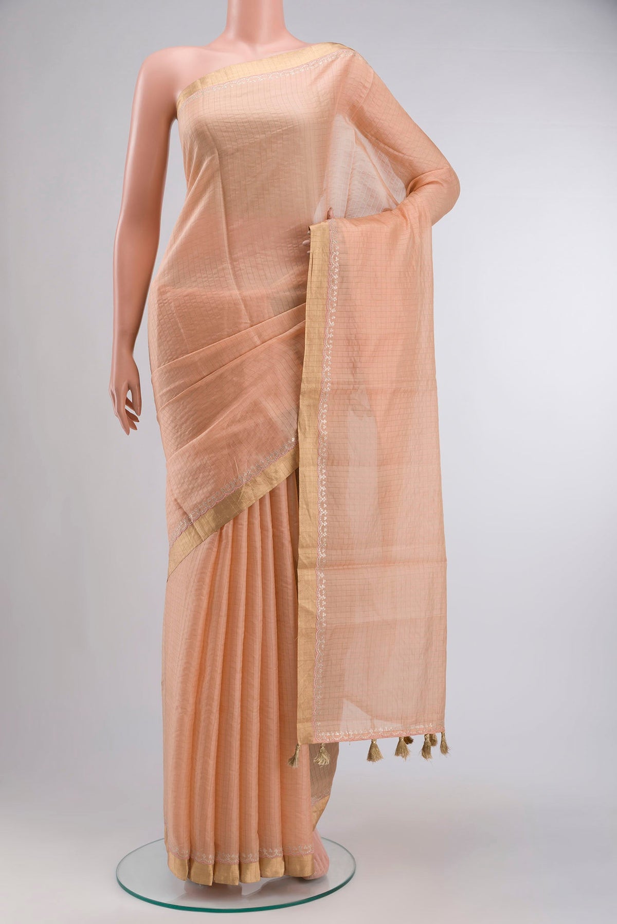 Peach Raw Silk Saree Checked design on the body and Zari Border displayed on a mannequin