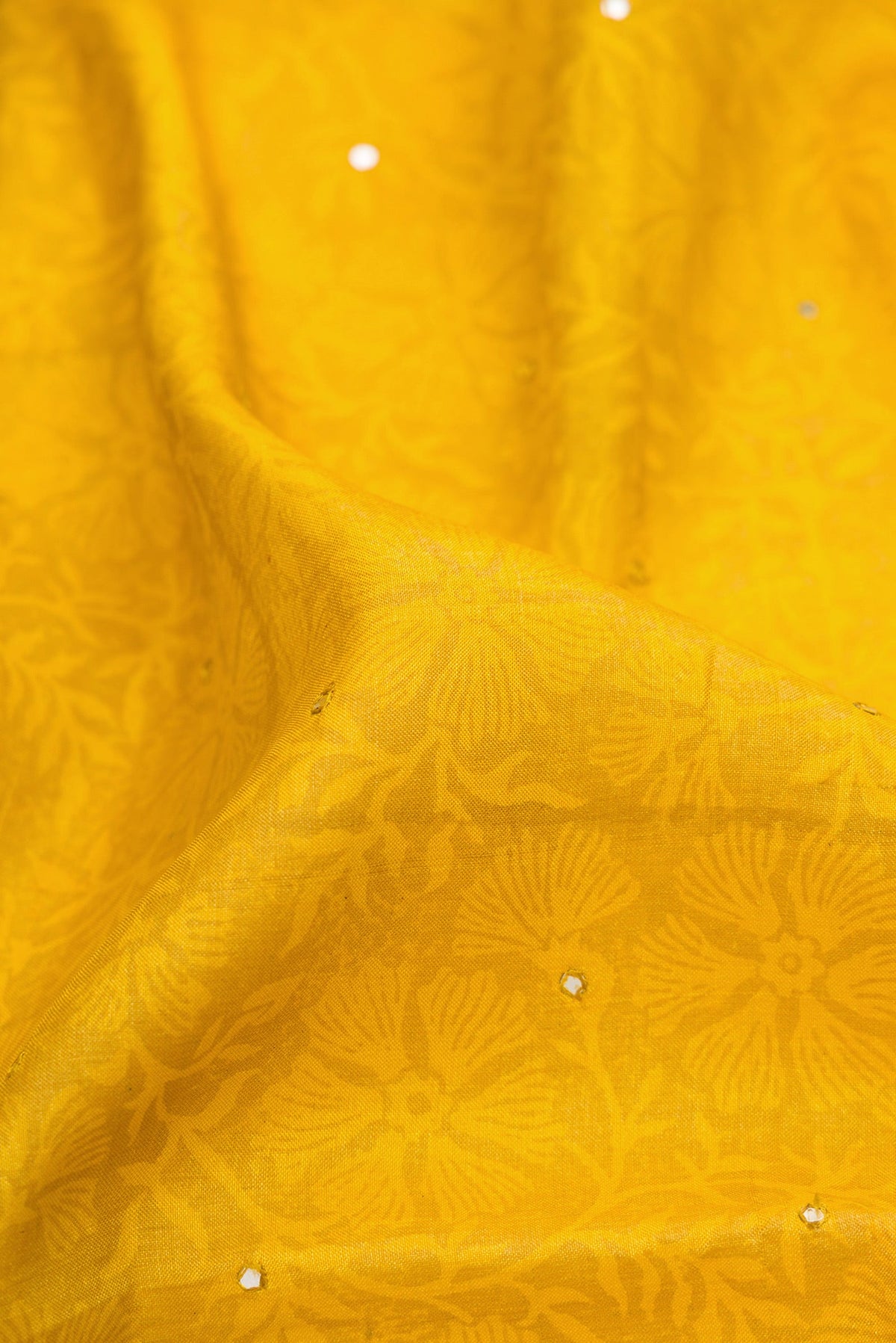 Close up of Mustard Dual Tone Tussar Silk Saree with Embroidery on the body and Embroidery Border.  displaying folds