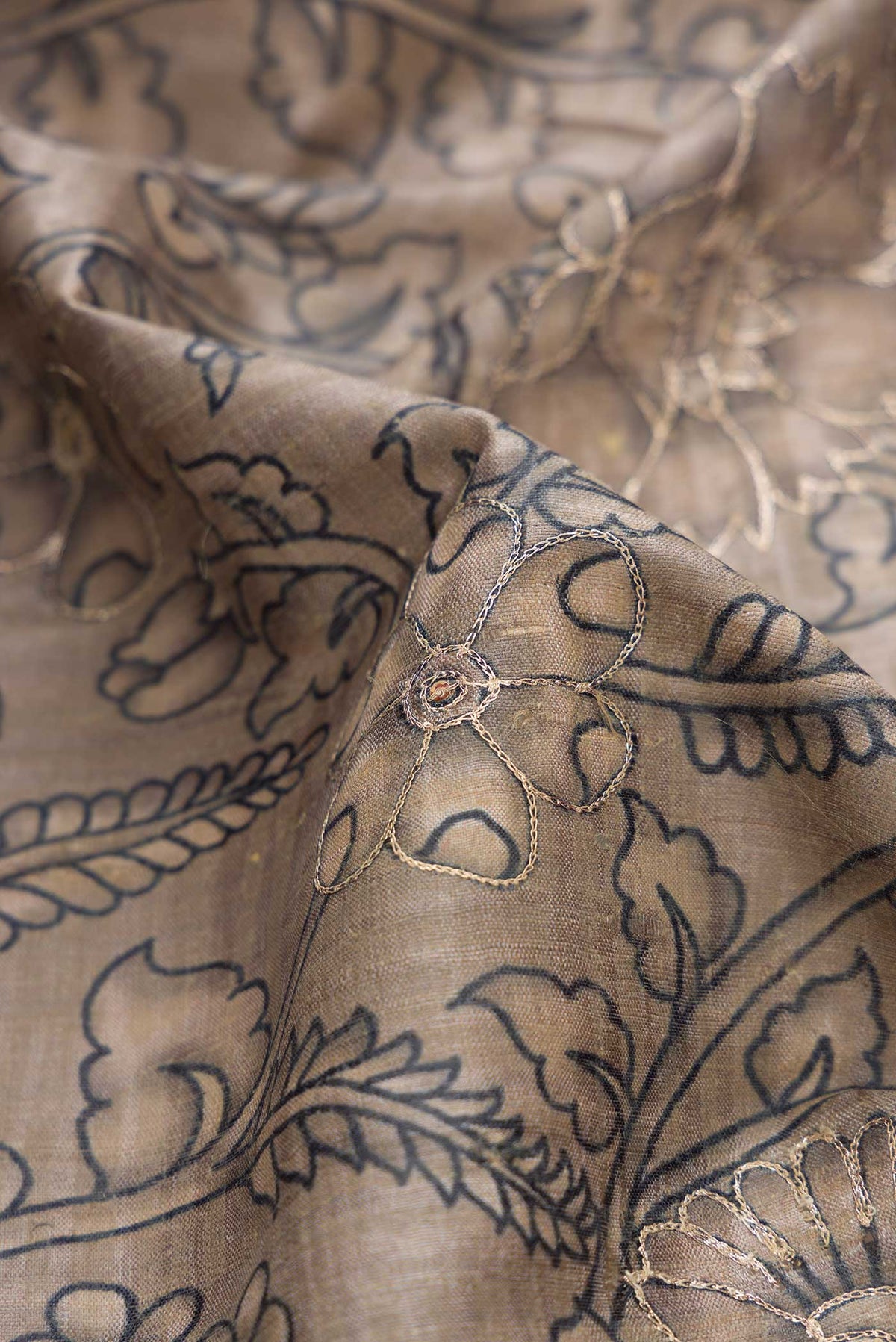 Close up of Grey Dual Tone Tussar Silk Saree with Printed design on the body and Embroidery Border displaying folds