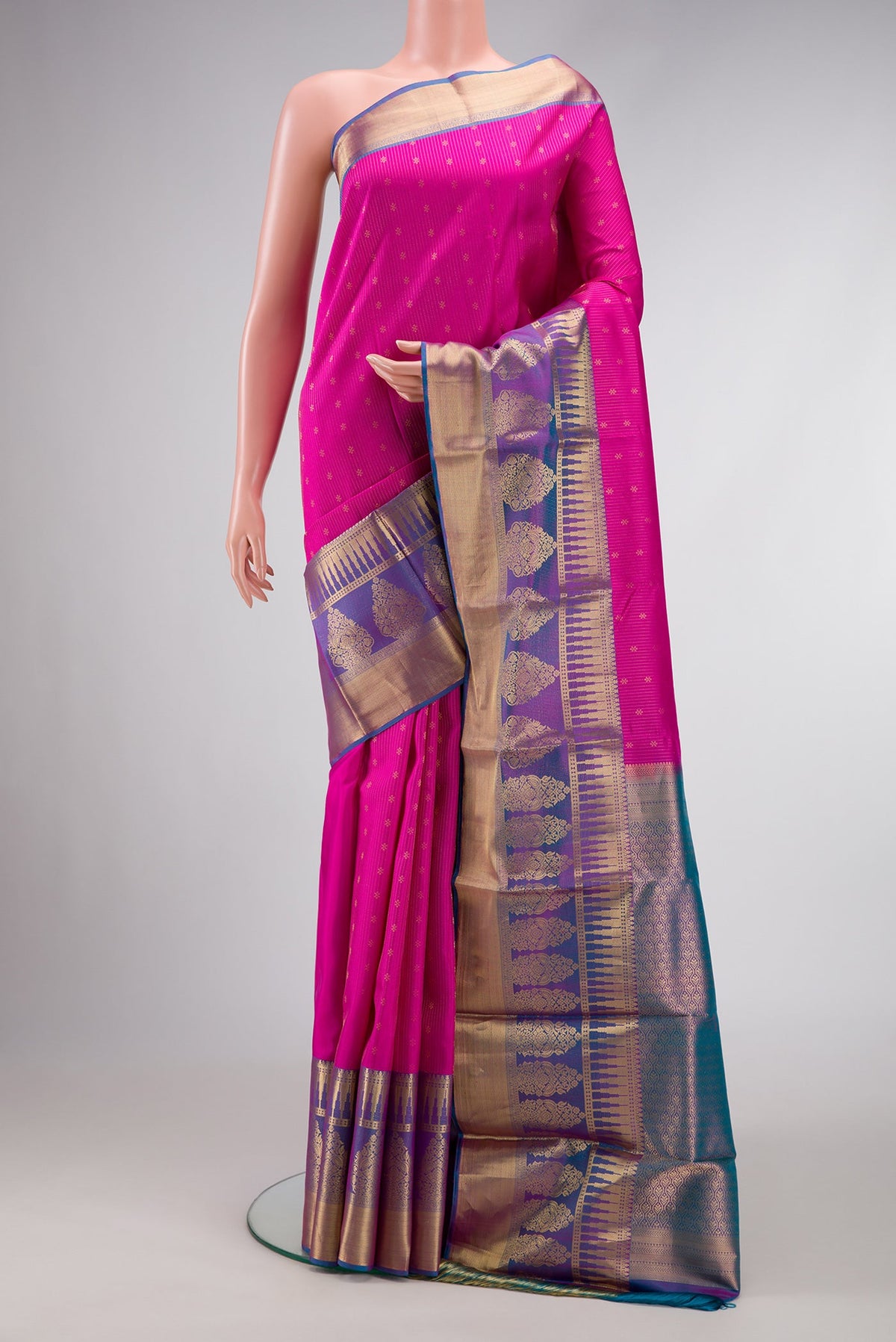 Pink Dual Tone Kanchipuram Silk Saree with Stripes on the body and Zari Border.  displayed on a mannequin