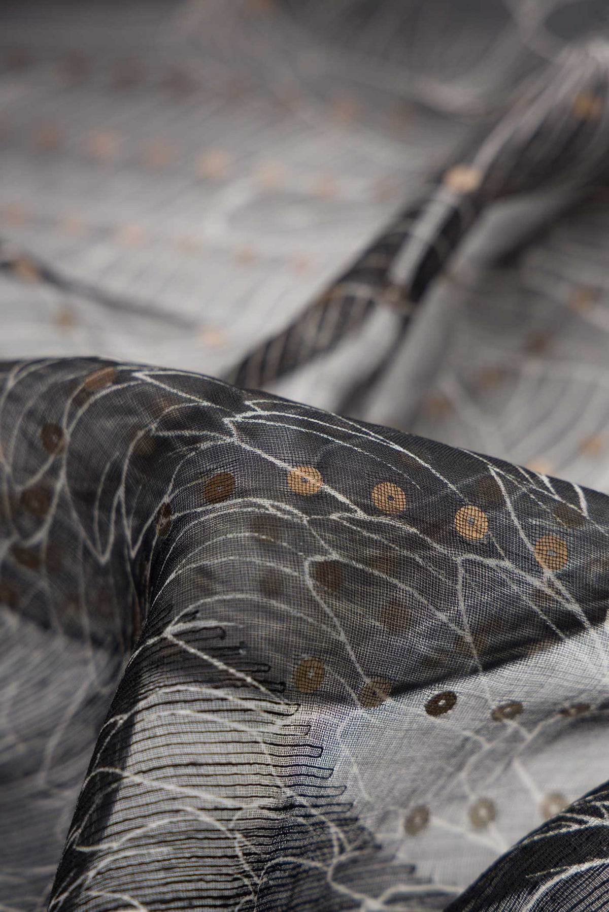 Close up of Black Dual Tone Tussar Silk Saree with Embroidery on the body and Without Border displaying folds