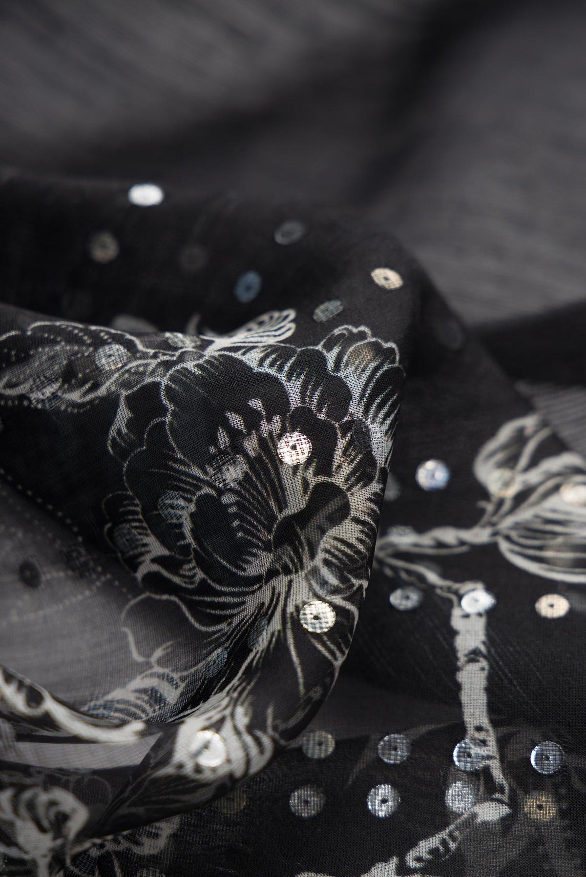 Close up of Black Dual Tone Tussar Silk Saree with Embroidery on the body and Printed Border displaying folds
