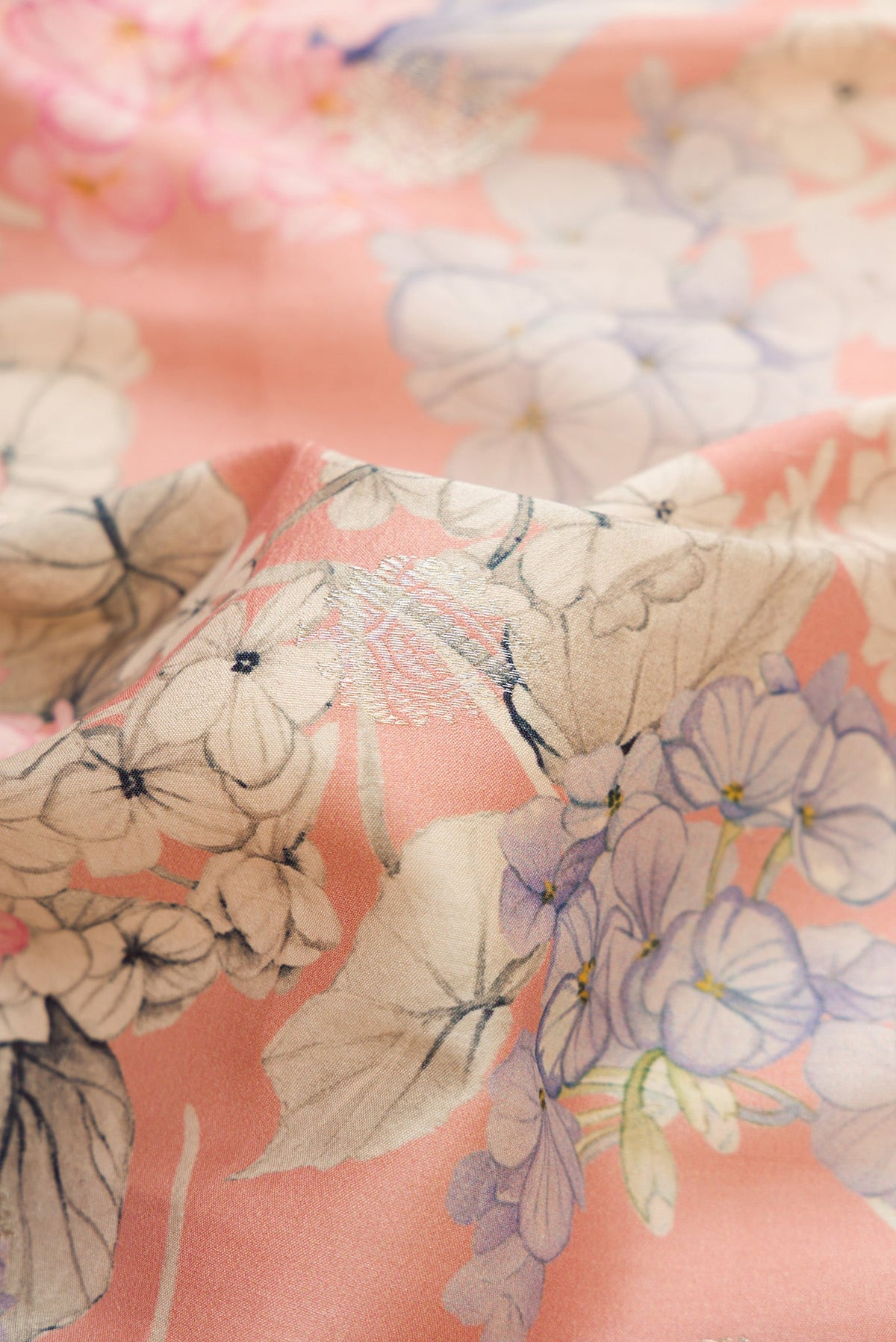 Close up of Rose Gold Dual Tone Tussar Silk Saree with Printed design on the body and Zari Border.  displaying folds