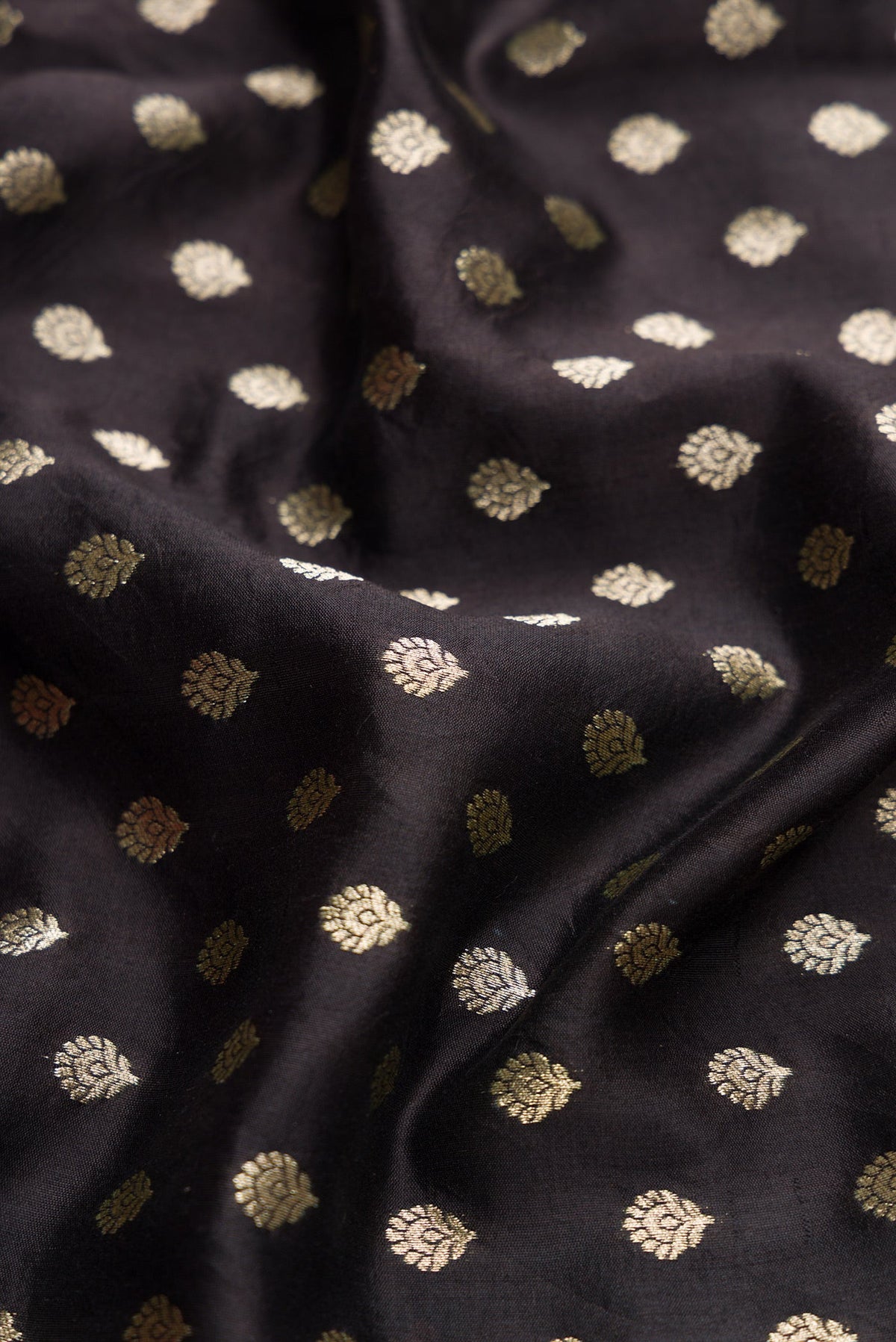 Close up of Black Dual Tone Tussar Silk Saree with Zari Butta on the body and Without Border.  displaying folds