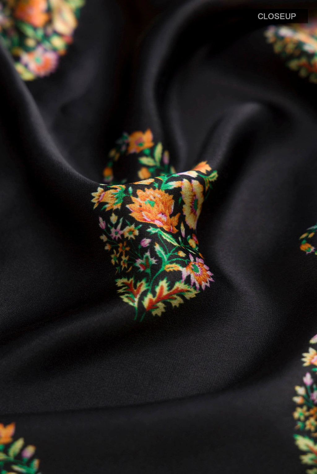 Close up of Black Satin Crepe Saree Printed design on the body and Plain Border displaying folds