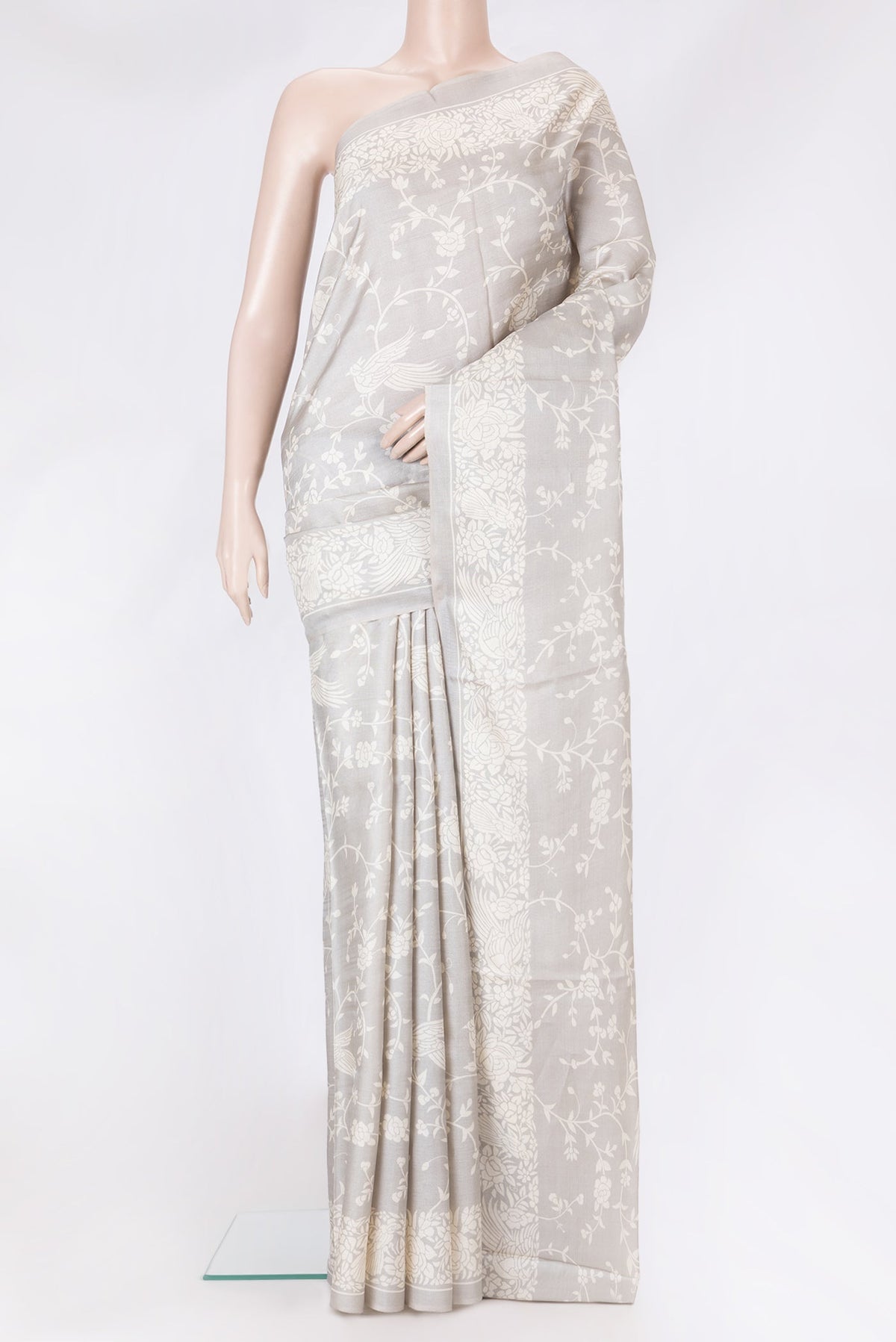 Grey Tussar Silk Saree with Printed design on the body and Printed Border.  displayed on a mannequin