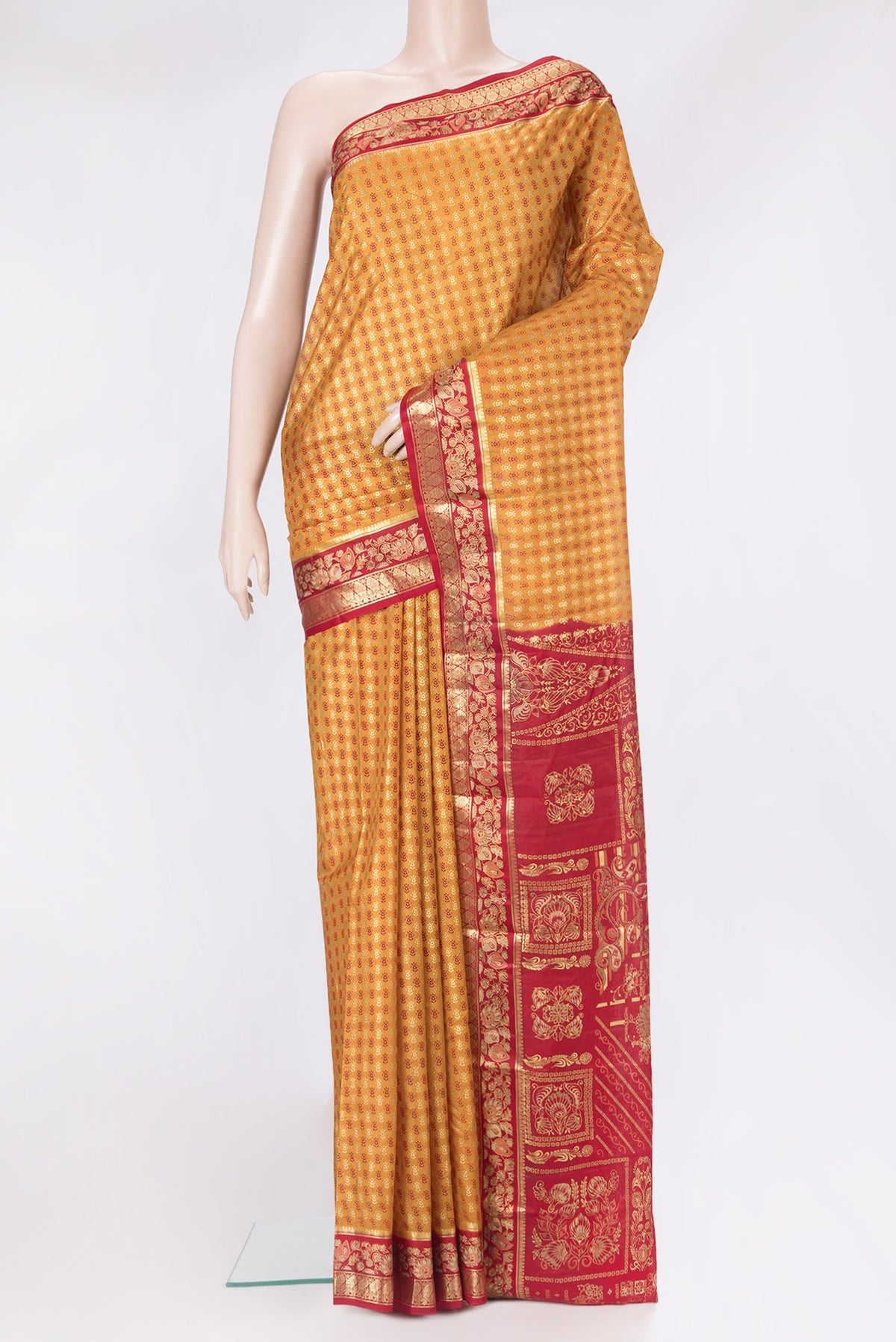 Mustard Printed Silk Saree with Printed design on the body and Zari Border.  displayed on a mannequin