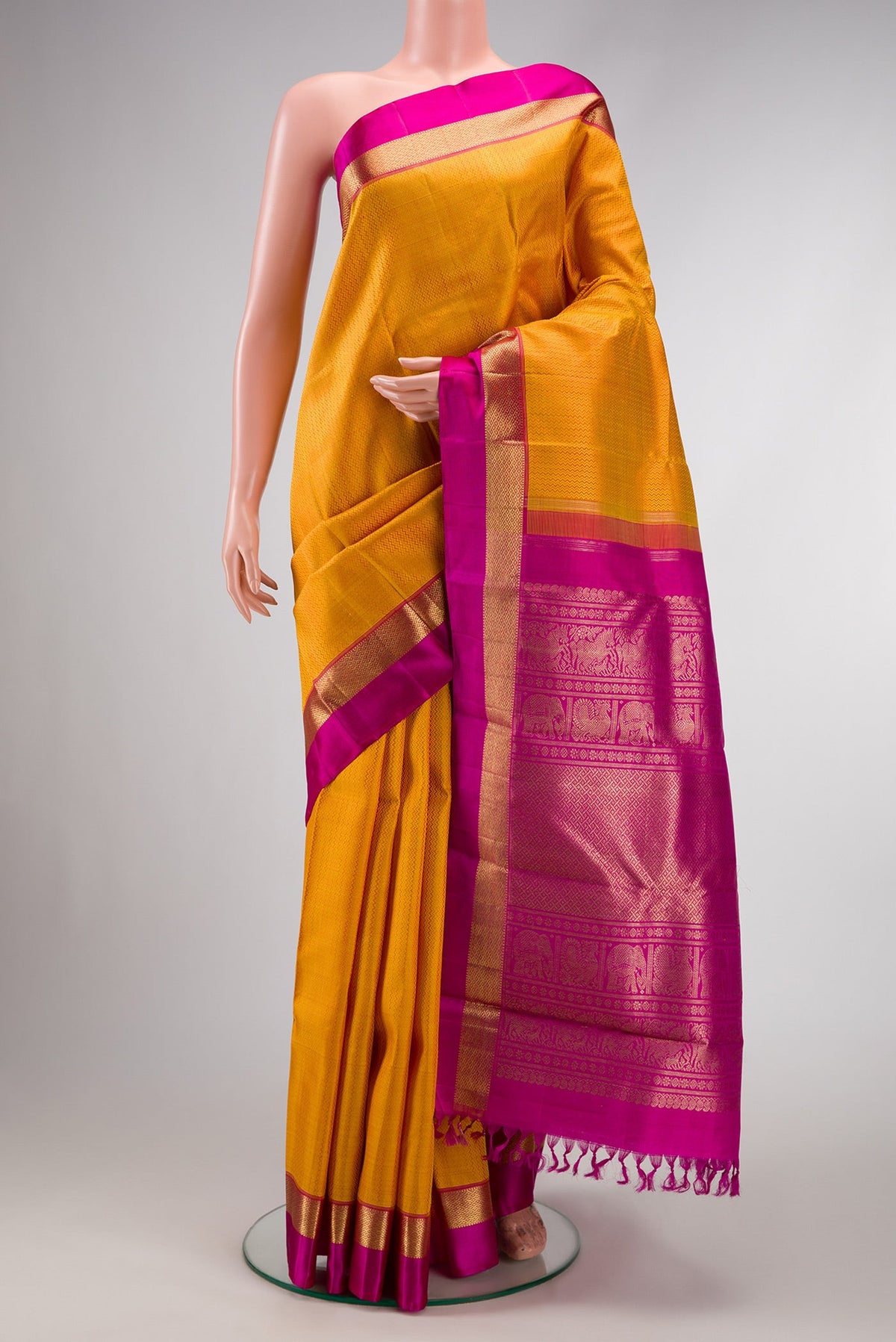 Pure Silk Pure Zari Mustard Dual Tone Kanchipuram Saree with Jacquard design on the body and Zari And Thread Border.  displayed on a mannequin