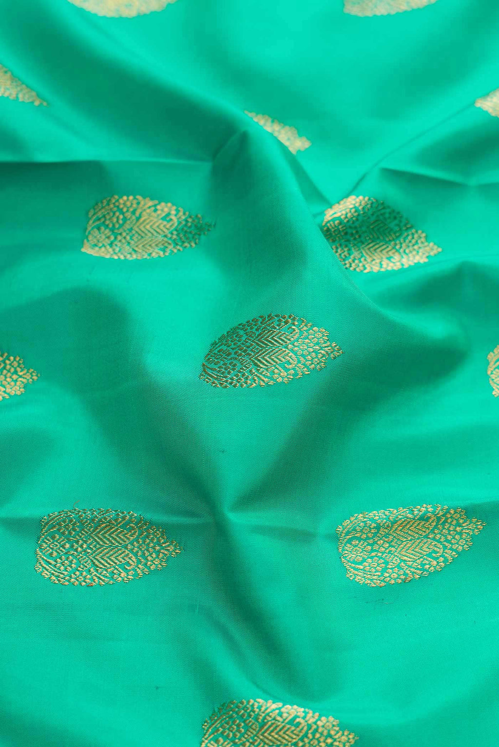 Close up of Pure Silk Pure Zari Sea Green Dual Tone Kanchipuram Saree with Zari Butta on the body and Zari Border displaying folds