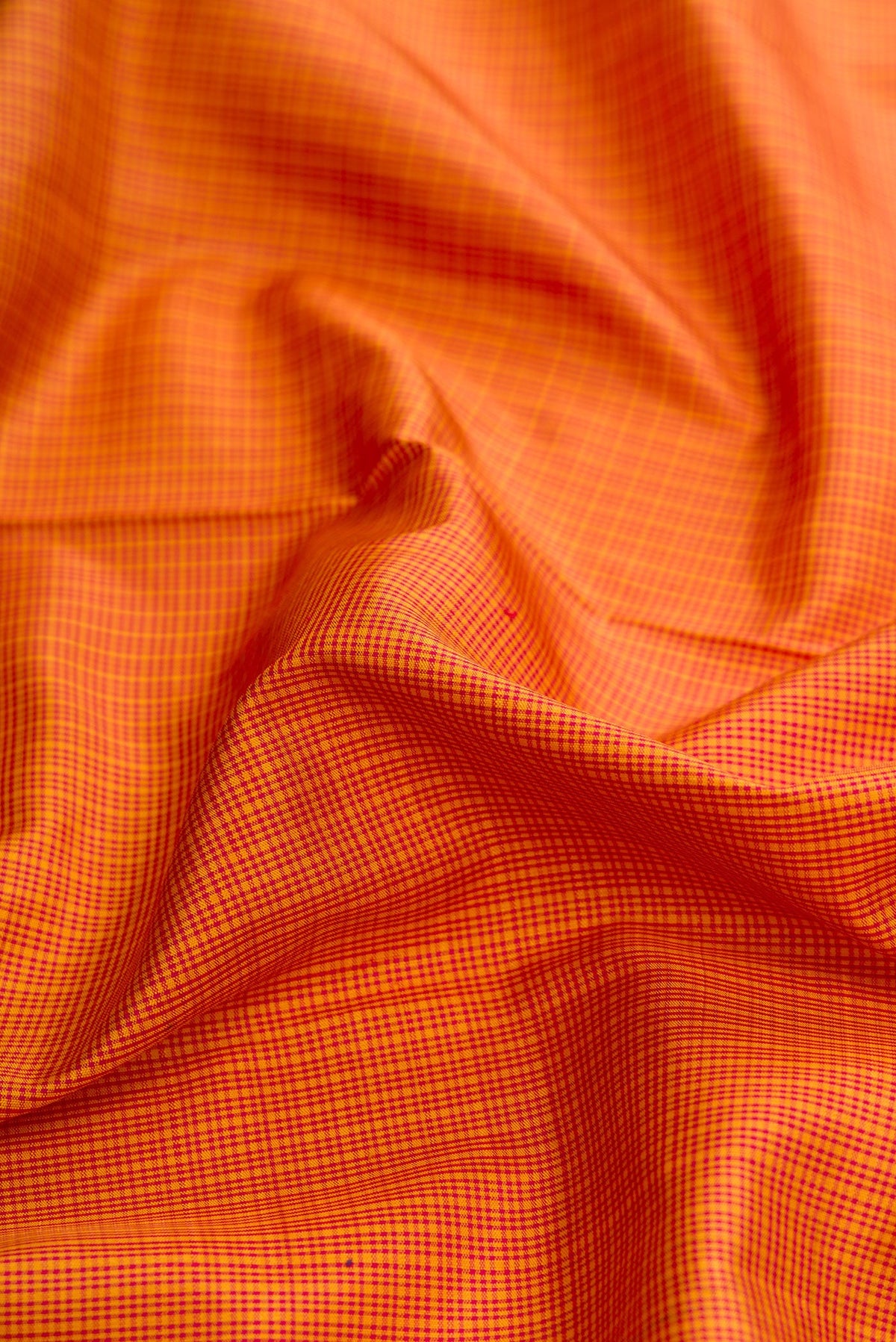 Close up of Mustard Dual Tone Kanjivaram Silk Saree with Checked design on the body and Zari Border.  displaying folds