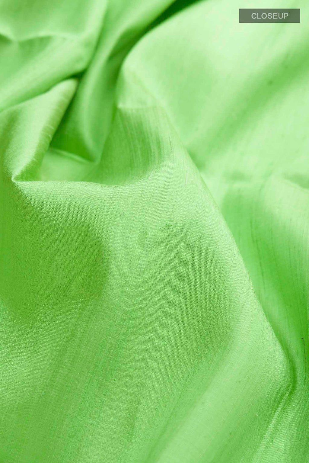 Close up of Pista Green Raw Silk Saree with Plain Body and Thread Border displaying folds